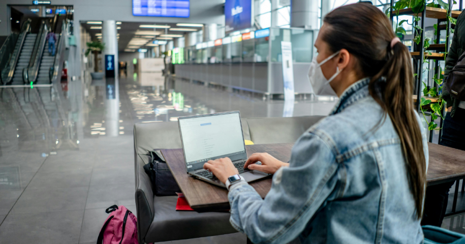 How to protect PHI when using public WiFi -- doctor working on a laptop at the airport