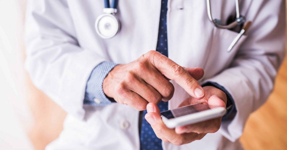 doctor holds an iPhone, a great tool for mobile medical dictation